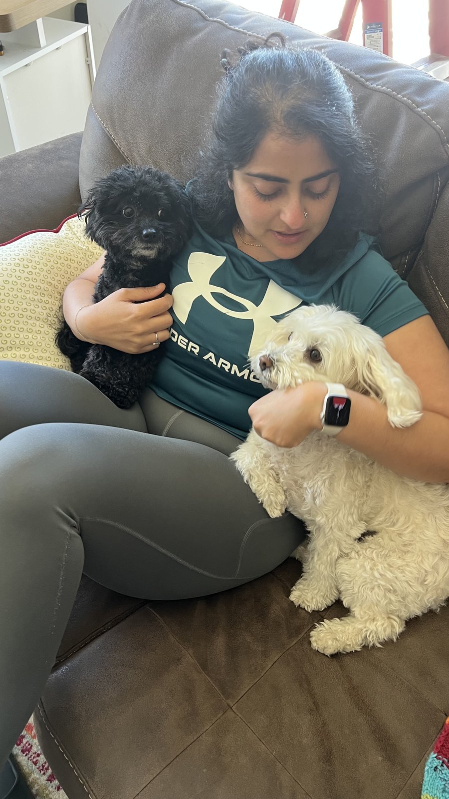 Ghazal holding a small black dog and a small white dog