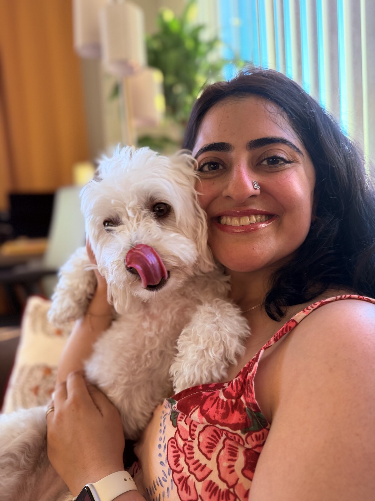 Ghazal smiling cheek-to-cheek with a fluffy white dog